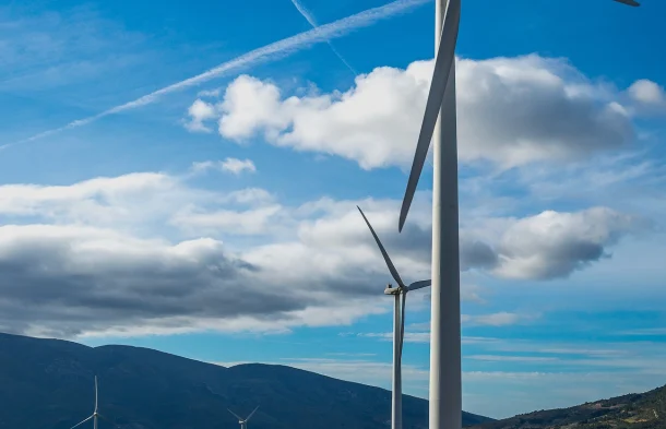 vertical-shot-several-white-electric-windmills-hill 1